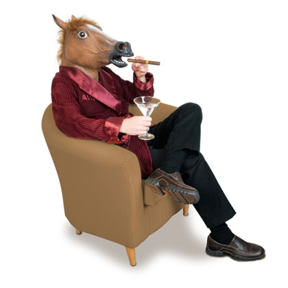 Человек в маске коня сидит в кресли и курит сигару
